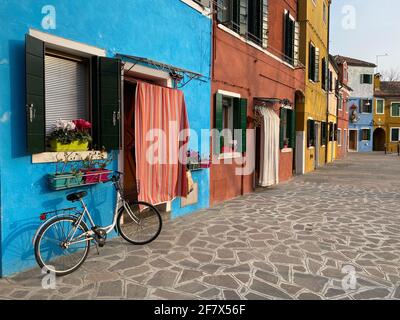 Vélo placé sur la façade d'une maison multicolore sur l'île de Burano, Venise Banque D'Images