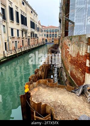 Travaille dans un canal de Venise. Ils utilisent des tas de feuilles larssen pour assécher la construction Banque D'Images