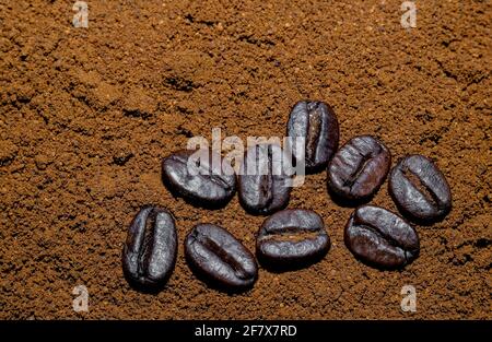 fond de café noir moulu avec quelques grains de café noir haricots Banque D'Images