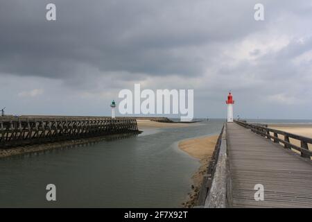 La plage de Trouville avec l'entrée du port avec phares et plates-formes en bois à marée basse au jour de tempête en septembre Banque D'Images