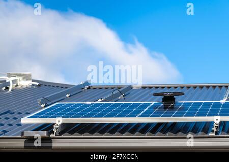 De nouveaux panneaux solaires sont installés sur le toit en tôle de La maison en Australie méridionale Banque D'Images