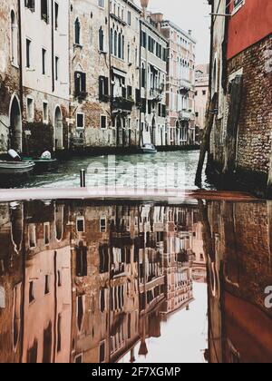 Maisons réflexions sur la cagoule en bois verni, ponton, du bateau-taxi dans les rues de Venise, qui part Banque D'Images