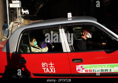 (210410) -- HONG KONG, le 10 avril 2021 (Xinhua) -- On voit des personnes portant un masque dans un taxi à Hong Kong, dans le sud de la Chine, le 10 avril 2021. Le Centre pour la protection de la santé (CHP) de Hong Kong a signalé cinq autres cas confirmés de COVID-19 samedi, portant son total à 11,568. (Module Xinhua/Li) Banque D'Images