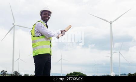 Ingénieur africain travaillant sur site avec l'éolienne Banque D'Images