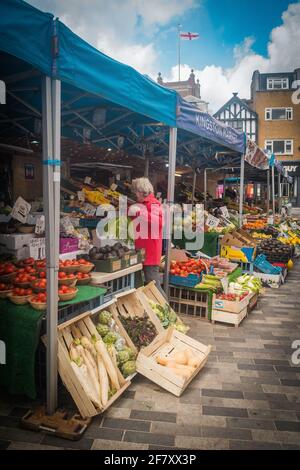 Une vieille femme magasinera dans un stand de fruits et légumes à Kingston Market, Londres, Royaume-Uni Banque D'Images