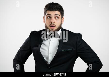 Homme irrité dans les soupirs de tuxedo, yeux roulés sur fond blanc. Caucasien gars dans le mécontentement, il est fatigué de la situation, pense comment vous ne pouvez pas encore Banque D'Images