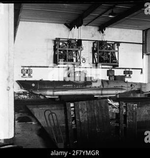 Intérieur endommagé d'un ancien bunker allemand dans le Waalhaven à Rotterdam. En arrière-plan il y a un mini sous-marin allemand Biber (Bever). Une torpille pourrait être fixée des deux côtés de la coque. Banque D'Images