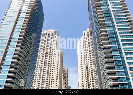 Gratte-ciels modernes vue symétrique à angle bas avec ciel bleu en arrière-plan, Dubai Marina, Émirats arabes Unis. Banque D'Images