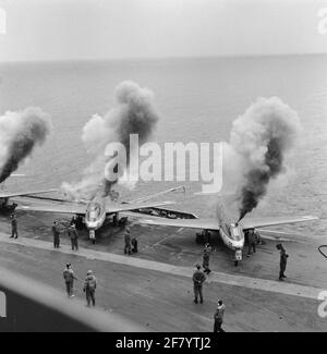 Un certain nombre d'aéronefs de grand standing Hawker FGA-50 Seahawk (jet) avec enregistrement O.A 50 (1957-1964) et 57 (1957-1964) du Service de l'aviation maritime (MLD) démarrent leurs moteurs au pont d'aéronef du camp d'aéronef HR.MS Karel portier (R 81, EX-VÉNÉRÉ) en 1958. Banque D'Images