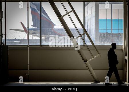 Moscou, Russie. 09e avril 2021. Un agent de sécurité aux lignes silhouettes se promène près d'une fenêtre de hangar lors de l'ouverture du centre D'ingénierie A-Technics à l'aéroport de Moscou-Sheremetyevo. Crédit : SOPA Images Limited/Alamy Live News Banque D'Images
