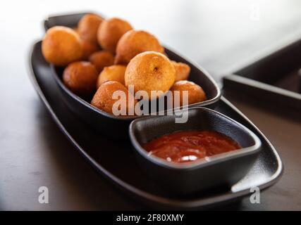 délicieux amuse-bouche avec sauce rouge dans une assiette noire Banque D'Images