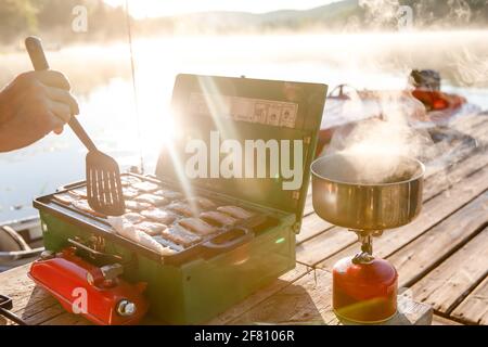 petite cuisinière verte portable avec bacon et une casserole un deuxième poêle au propane Banque D'Images