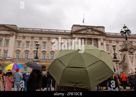 Les gens avec des parasols assistent au Prince Philip Tribute.les Londoniens posent des fleurs aux portes de Buckingham Palace pour rendre hommage au Prince Philippe qui est décédé le 9 avril à l'âge de 99 ans. Banque D'Images