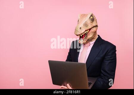 Homme euphorique avec tête de lézard avec ordinateur portable Banque D'Images