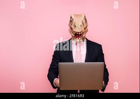 Homme euphorique avec tête de lézard avec ordinateur portable Banque D'Images