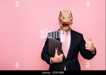 Homme euphorique avec tête de lézard avec ordinateur portable Banque D'Images