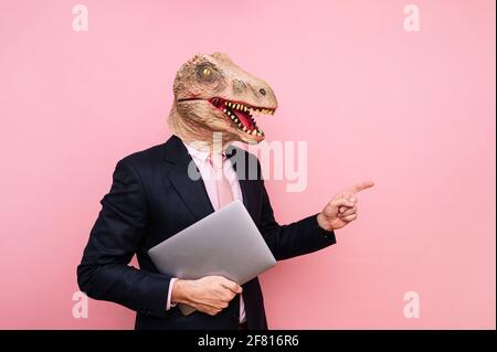 Homme euphorique avec tête de lézard avec ordinateur portable Banque D'Images