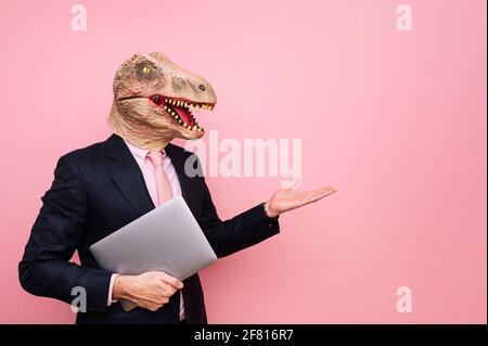 Homme euphorique avec tête de lézard avec ordinateur portable Banque D'Images