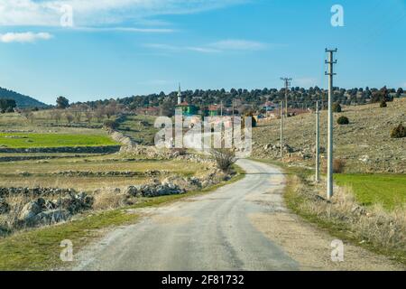 Chemin d'asphalte sinueux menant au village au sommet d'une colline Banque D'Images