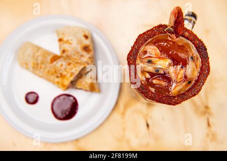 Vue de dessus de Sulguni enveloppé de lavash sur un blanc assiette avec bloody mary Banque D'Images