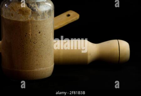 Masa mater en flacon, fermenté et levain. Avec broche roulante et cuillère en bois, tous faits maison isolés sur fond noir Banque D'Images