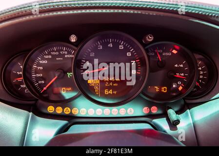 Le cockpit d'une voiture sport affiche des jauges avec tous les témoins allumés sur le compteur de vitesse. Banque D'Images