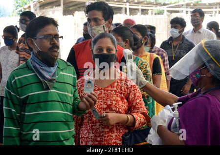 Inde. 10 avril 2021. Des volontaires vérifient la température corporelle des électeurs et distribuent des gants dans un bureau de vote lors de la quatrième phase des élections de l'État du Bengale occidental à Kolkata, en Inde, le samedi 10 avril 2021. (Photo de Sanjay Purkait/Pacific Press/Sipa USA) crédit: SIPA USA/Alay Live News Banque D'Images