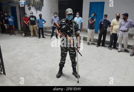 Inde. 10 avril 2021. Un soldat paramilitaire garde tandis que les électeurs attendent à l'extérieur d'un bureau de vote pendant la quatrième phase des élections de l'État du Bengale occidental à Kolkata, en Inde, le samedi 10 avril 2021. (Photo de Sanjay Purkait/Pacific Press/Sipa USA) crédit: SIPA USA/Alay Live News Banque D'Images