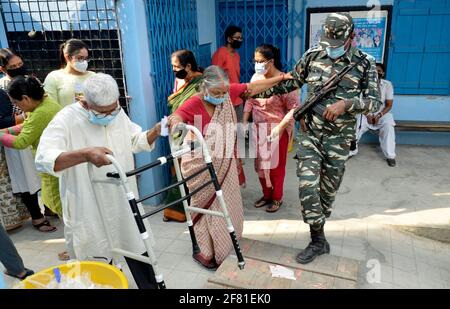 Inde. 10 avril 2021. Un soldat paramilitaire aide un électeur âgé à l'extérieur d'un bureau de vote pendant la quatrième phase des élections de l'État du Bengale occidental à Kolkata, en Inde, le samedi 10 avril 2021. (Photo de Sanjay Purkait/Pacific Press/Sipa USA) crédit: SIPA USA/Alay Live News Banque D'Images