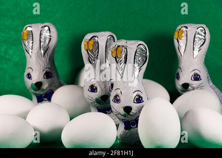 Lapins au chocolat et œufs de Pâques à la Candy blanche sur le vert Banque D'Images