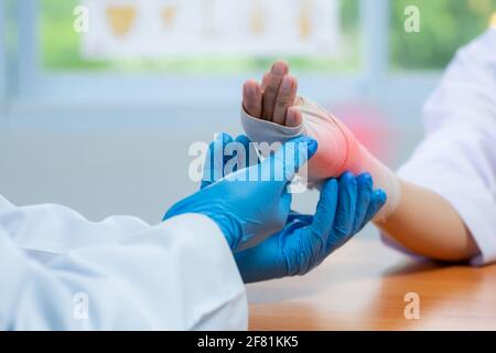 Médecin orthopédique porter des gants médicaux de Doctor Hand Ting Bandage Sur l'inflammation du poignet du patient en clinique Banque D'Images