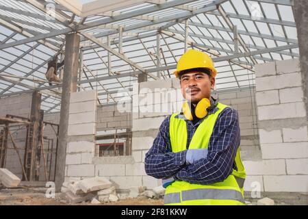 Portrait de l'ingénieur de construction technicien travailleur, ingénieur civil vérifiant la structure du toit de la maison inachevée sur le chantier de construction, Maison c Banque D'Images