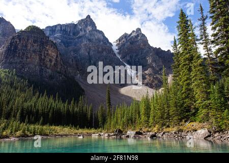 Haute montagne sur une journée ensoleillée derrière un lac qui il est vert dans l'ombre Banque D'Images