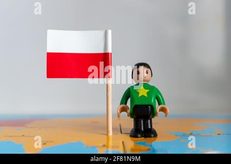 POZNAN, POLOGNE - 06 avril 2021 : figurine jouet joutive située à côté d'un drapeau national polonais. Banque D'Images