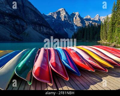 Les bateaux de couleur se sont retournés sur le quai à côté d'un lac turquoise en été avec des sommets de montagne en arrière-plan en été Banque D'Images