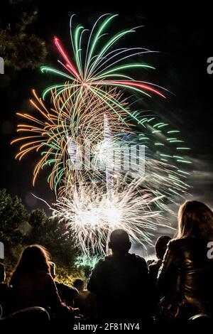 MADRID, ESPAGNE - 16 mai 2018 : 16 mai 2018, Madrid, Espagne. Photo verticale de quelques personnes de derrière, assis dans un pré vert, regardant les feux d'artifice Banque D'Images