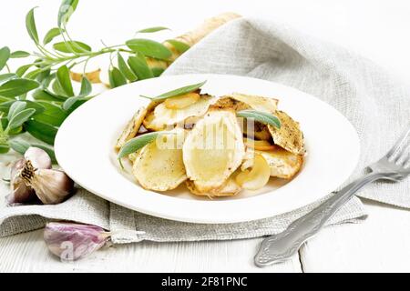 Panais cuits aux épices, à l'ail et à la sauge dans une assiette sur une serviette sur fond de bois clair Banque D'Images