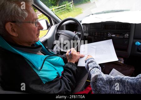 Père et fille discutant de la route en voiture. D'en haut, un homme âgé et une femme adulte tentent de trouver des directions tout en étant assis en voiture pendant le voyage. Banque D'Images