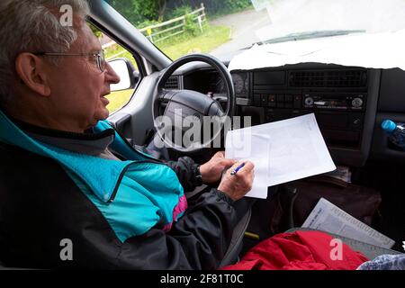 Père et fille discutant de la route en voiture. D'en haut, un homme âgé et une femme adulte tentent de trouver des directions tout en étant assis en voiture pendant le voyage. Banque D'Images