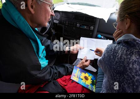 Père et fille discutant de la route en voiture. D'en haut, un homme âgé et une femme adulte tentent de trouver des directions tout en étant assis en voiture pendant le voyage. Banque D'Images