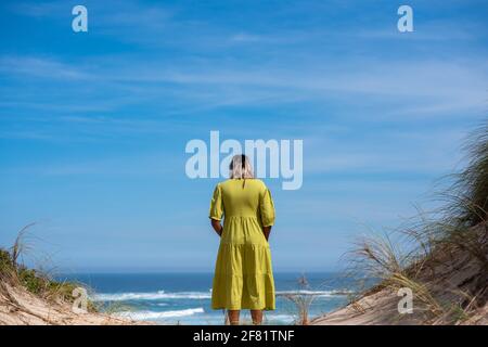Femme debout sur la falaise et regardant la mer Banque D'Images