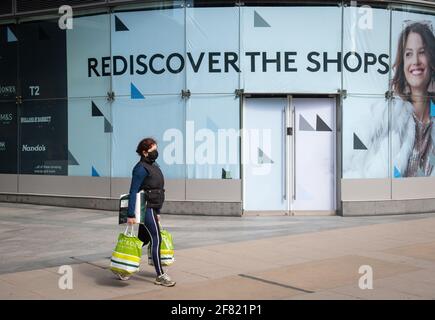 Photo du dossier datée du 06/04/21, d'une femme portant un masque facial de protection passant devant des boutiques non essentielles fermées dans le centre de Londres. Les détaillants espèrent une demande qui va augmenter et le plaisir du « magasinage physique » va voir les consommateurs revenir dans les magasins de briques et de mortier après une année mouvementée de fermetures et de restrictions. Date de publication : dimanche 11 avril 2021. Banque D'Images