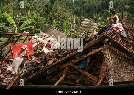 East Java, Indonésie. 11 avril 2021. (Les gens collectent leur appartenance à proximité de maisons endommagées après qu'un séisme de magnitude 6.1 ait frappé le village de Kali Uling à Lumajang, East Java, Indonésie, le 11 avril 2021. Six personnes ont été tuées, une autre grièvement blessée et des dizaines de bâtiments ont été endommagés après un séisme de magnitude 6.1 qui a secoué samedi la province orientale de Java en Indonésie, à l'ouest de l'île, a déclaré les responsables. Le tremblement de terre a frappé à 14 heures crédit: Xinhua/Alamy Live News Banque D'Images