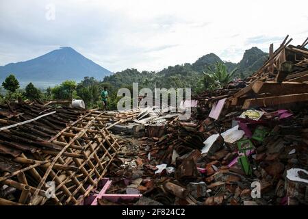 East Java, Indonésie. 11 avril 2021. (Un homme marche près de maisons endommagées après un séisme de magnitude 6.1 a frappé le village de Kali Uling à Lumajang, Java-est, Indonésie, le 11 avril 2021. Six personnes ont été tuées, une autre grièvement blessée et des dizaines de bâtiments ont été endommagés après un séisme de magnitude 6.1 qui a secoué samedi la province orientale de Java en Indonésie, à l'ouest de l'île, a déclaré les responsables. Le tremblement de terre a frappé à 14 heures crédit: Xinhua/Alamy Live News Banque D'Images