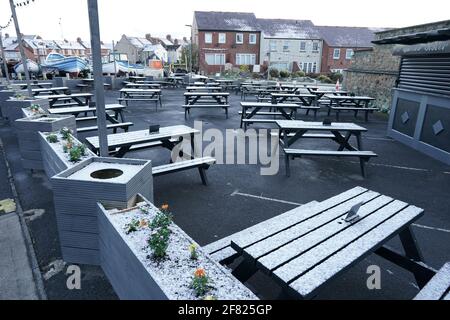 Un léger dépoussiérage de neige couvre le coin salon extérieur du Queens Head à Cullercoats, sur la côte nord-est, tandis que le pub se prépare à rouvrir son espace extérieur à partir d'avril 12, et les clients y sont invités à nouveau à partir de mai 17. Date de la photo: Dimanche 11 avril 2021. Banque D'Images