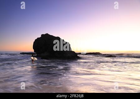 Surfeur à la marée haute pour surfer sur Currumbin Alley, Gold Coast, Queensland, Australie. Banque D'Images