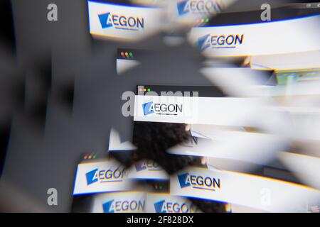 Milan, Italie - 10 AVRIL 2021 : logo AEGON sur écran d'ordinateur portable vu à travers un prisme optique, interprétation créative. Image dynamique et unique d'Aegon Banque D'Images