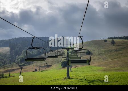 Télésiège au sommet de la montagne. Remontée mécanique vide dans la station de ski de Mala fatra, Slovaquie au printemps. Ciel nuageux Banque D'Images