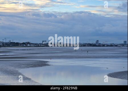 Belle vue en soirée de Blackrock Beach à marée basse avec Aviva Stadium et beaucoup de grues de construction en arrière-plan, Dublin Irlande Banque D'Images