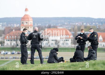 11 avril 2021, Saxe, Dresde: Des policiers se tiennent à côté d'un groupe de manifestants devant le parc des expositions. La conférence du parti fédéral de l'AfD se tiendra au centre des expositions du 10 au 11 avril 2021. Photo: Sebastian Kahnert/dpa-Zentralbild/dpa Banque D'Images